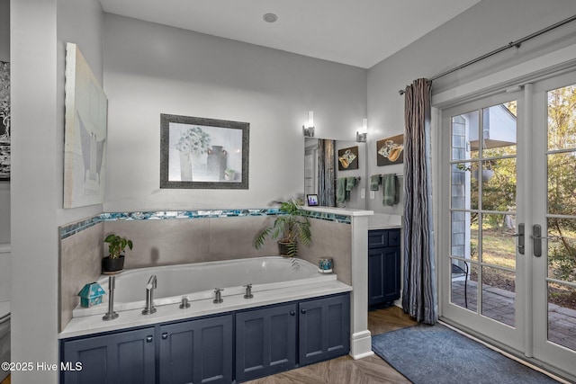 bathroom featuring a tub to relax in, french doors, and parquet flooring