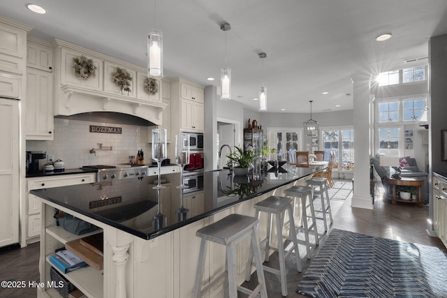 kitchen with a breakfast bar, hanging light fixtures, and a large island