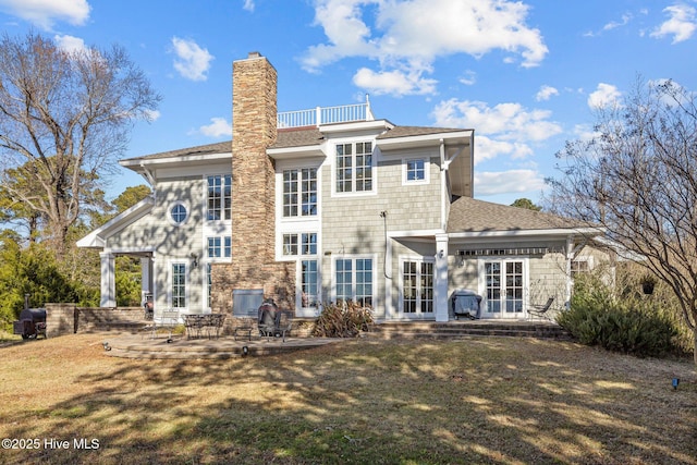 back of property with french doors, a patio area, and a lawn