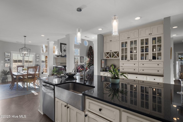 kitchen featuring pendant lighting, dishwasher, dark parquet flooring, sink, and a chandelier