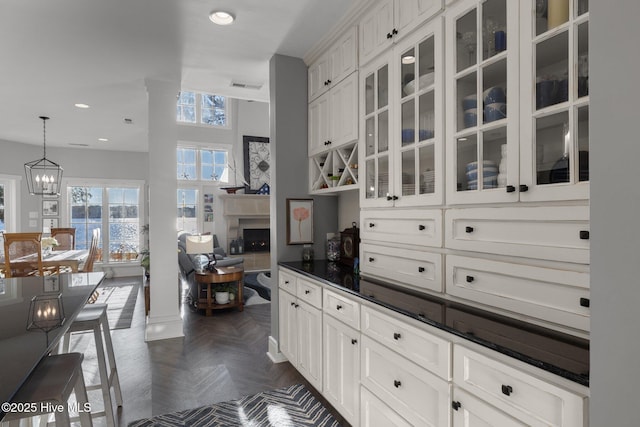 kitchen featuring pendant lighting, white cabinetry, dark parquet floors, and a chandelier