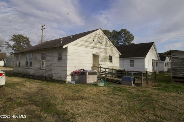 back of property featuring a yard and a deck