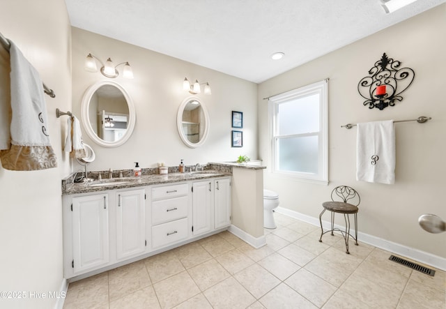 bathroom with a textured ceiling, toilet, vanity, and tile patterned flooring