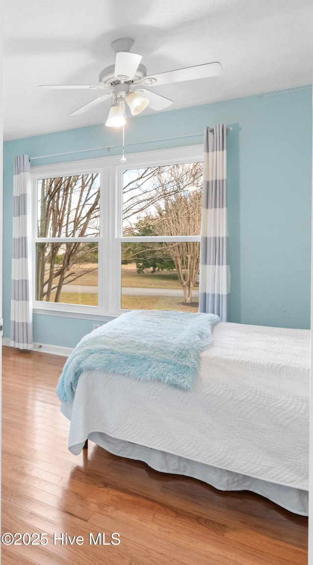 bedroom with ceiling fan and hardwood / wood-style floors