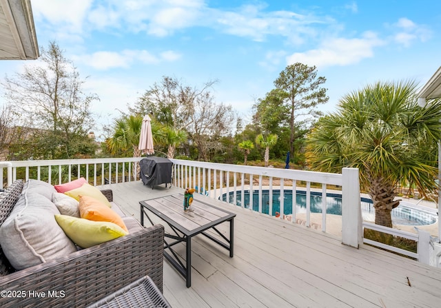 wooden terrace with outdoor lounge area and area for grilling