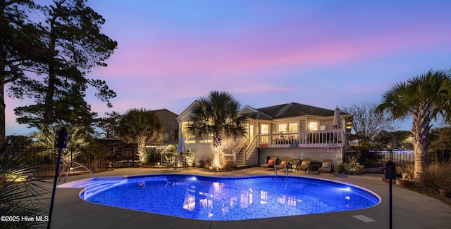 pool at dusk featuring a patio