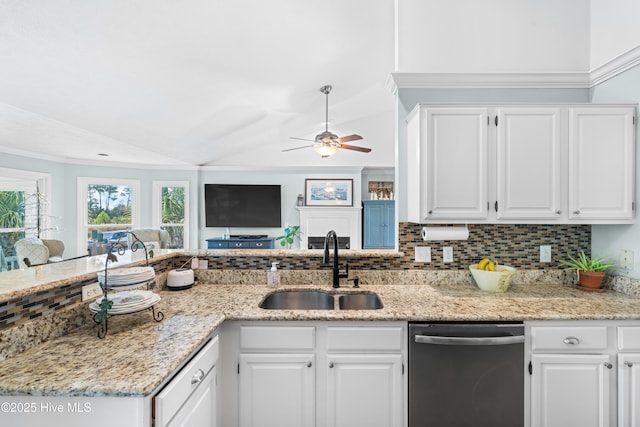 kitchen featuring stainless steel dishwasher, vaulted ceiling, sink, and white cabinetry