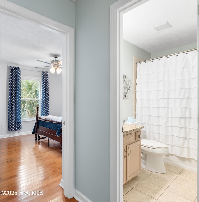 full bathroom with toilet, ceiling fan, shower / bath combination with curtain, tile patterned floors, and vanity