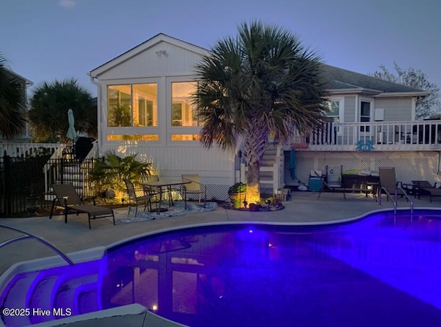 pool at dusk featuring a patio area