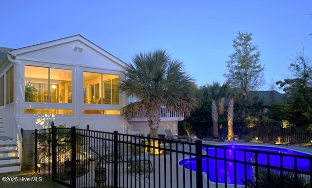 pool at dusk with a sunroom