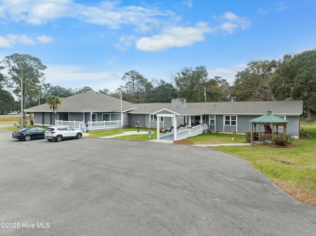 single story home featuring a front lawn, a porch, and a gazebo