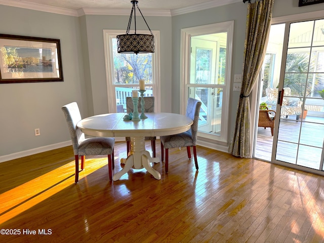 dining area with plenty of natural light, ornamental molding, and hardwood / wood-style floors