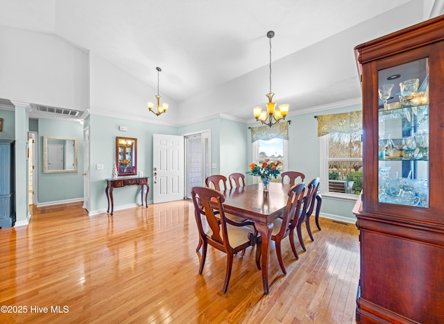 dining space featuring vaulted ceiling, light hardwood / wood-style flooring, and an inviting chandelier