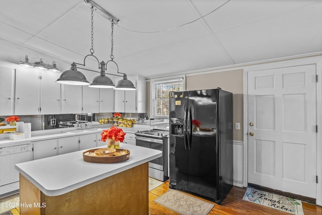 kitchen with white cabinetry, stainless steel electric range oven, hanging light fixtures, black refrigerator with ice dispenser, and a kitchen island