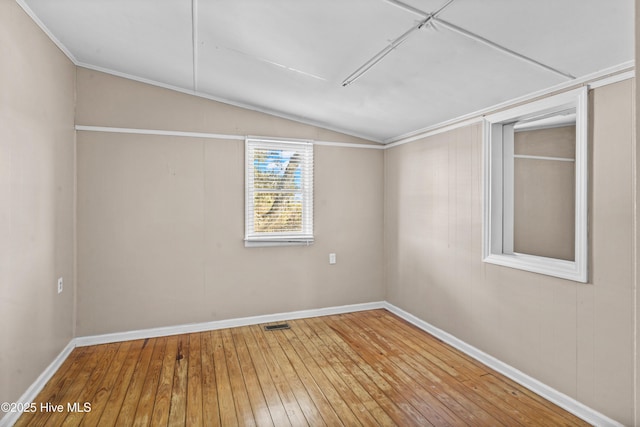 unfurnished room featuring hardwood / wood-style floors and lofted ceiling