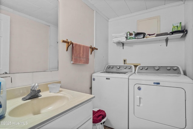 laundry room with crown molding, washer and clothes dryer, and sink