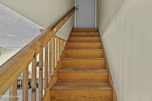 stairs featuring a textured ceiling