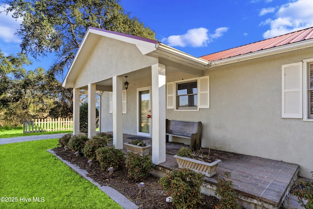 entrance to property with a lawn and covered porch