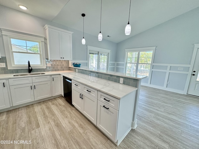 kitchen with pendant lighting, white cabinets, sink, black dishwasher, and kitchen peninsula