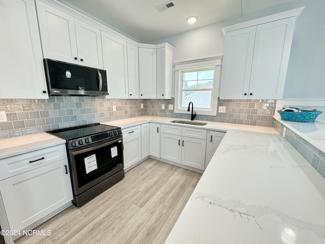 kitchen featuring white cabinetry, sink, light stone counters, black electric range, and light hardwood / wood-style flooring