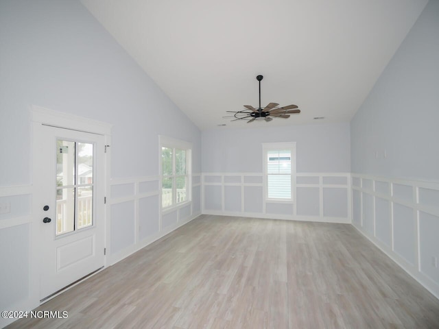 empty room with ceiling fan, plenty of natural light, lofted ceiling, and light wood-type flooring