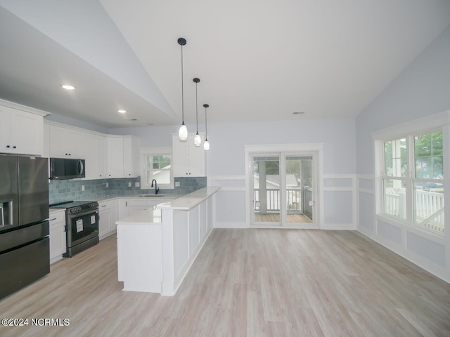 kitchen featuring kitchen peninsula, appliances with stainless steel finishes, white cabinets, hanging light fixtures, and lofted ceiling