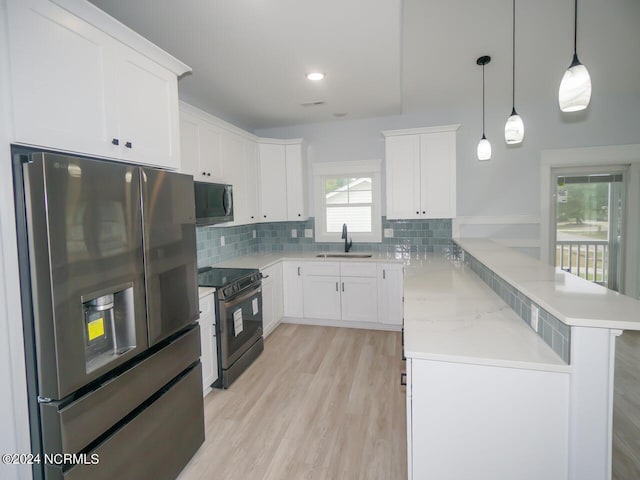 kitchen featuring electric range, white cabinetry, stainless steel fridge with ice dispenser, and kitchen peninsula