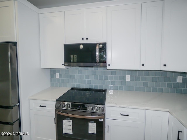 kitchen featuring decorative backsplash, white cabinetry, and appliances with stainless steel finishes