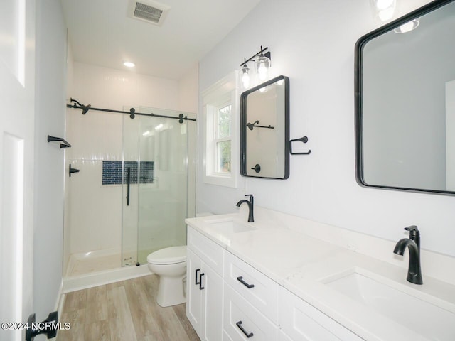 bathroom with vanity, wood-type flooring, an enclosed shower, and toilet