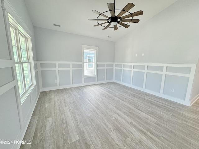 spare room featuring ceiling fan, plenty of natural light, lofted ceiling, and light hardwood / wood-style flooring