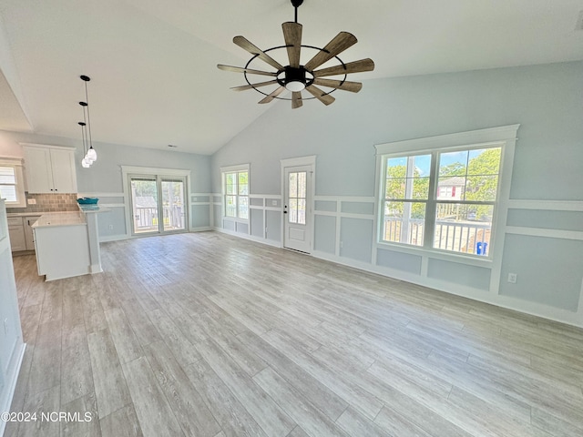 unfurnished living room featuring light hardwood / wood-style floors, ceiling fan, and lofted ceiling