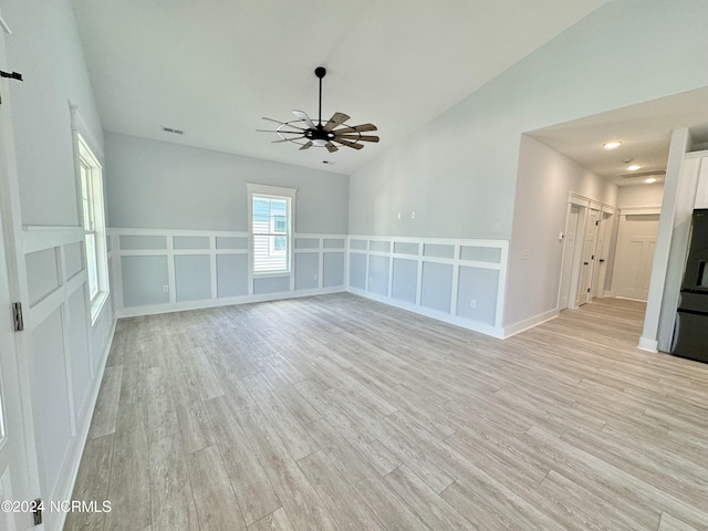 spare room featuring light wood-type flooring, ceiling fan, and lofted ceiling