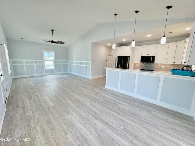 kitchen with ceiling fan, black appliances, pendant lighting, white cabinets, and lofted ceiling