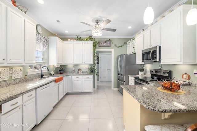 kitchen featuring decorative light fixtures, white cabinetry, stainless steel appliances, sink, and ornamental molding