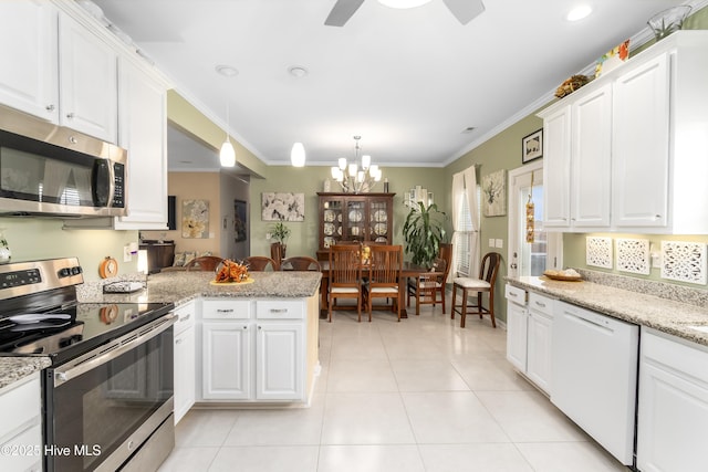 kitchen featuring crown molding, appliances with stainless steel finishes, white cabinetry, hanging light fixtures, and ceiling fan with notable chandelier