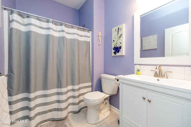 bathroom featuring tile patterned floors, toilet, vanity, and tasteful backsplash