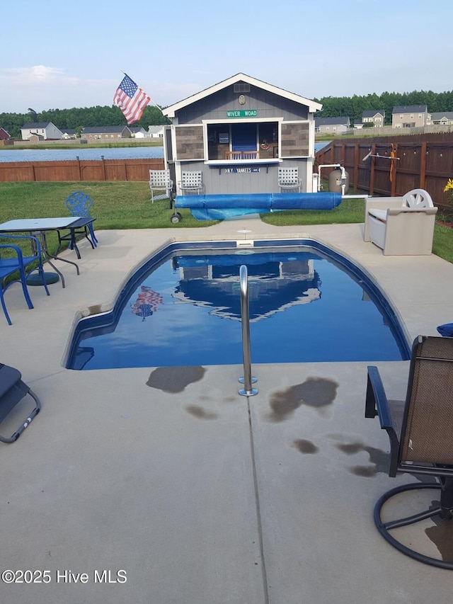 view of swimming pool featuring a lawn and a patio