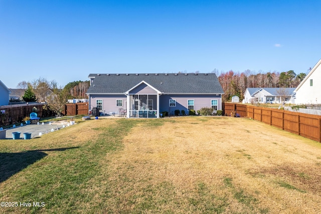 back of property featuring a sunroom and a lawn