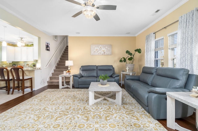 living room with ceiling fan, ornamental molding, and dark wood-type flooring