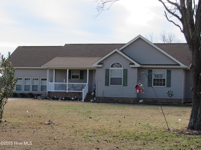 ranch-style house featuring covered porch and a front yard