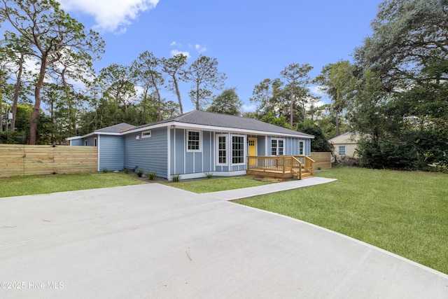 ranch-style home featuring a front yard and a wooden deck