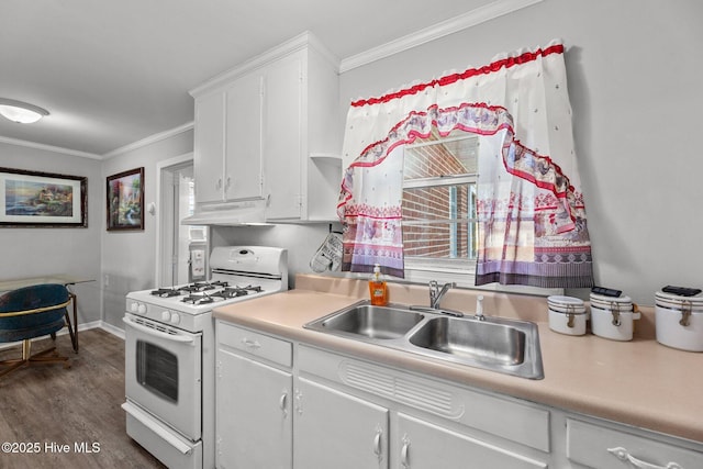 kitchen featuring white cabinets, a wealth of natural light, white gas stove, and sink