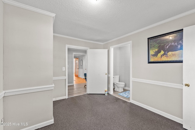 carpeted empty room with crown molding and a textured ceiling