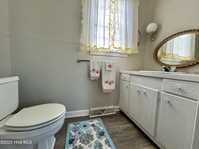 bathroom with wood-type flooring, vanity, and toilet