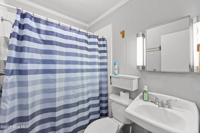 bathroom featuring a shower with shower curtain, toilet, ornamental molding, and sink