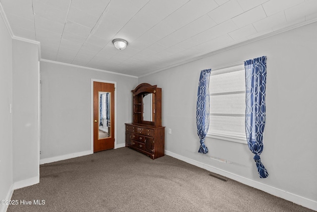 empty room featuring crown molding and carpet