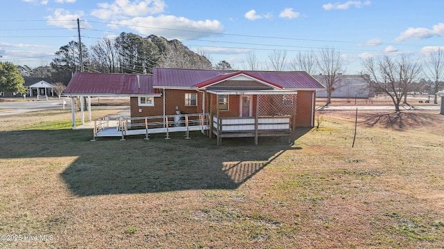 rear view of house featuring a lawn and covered porch