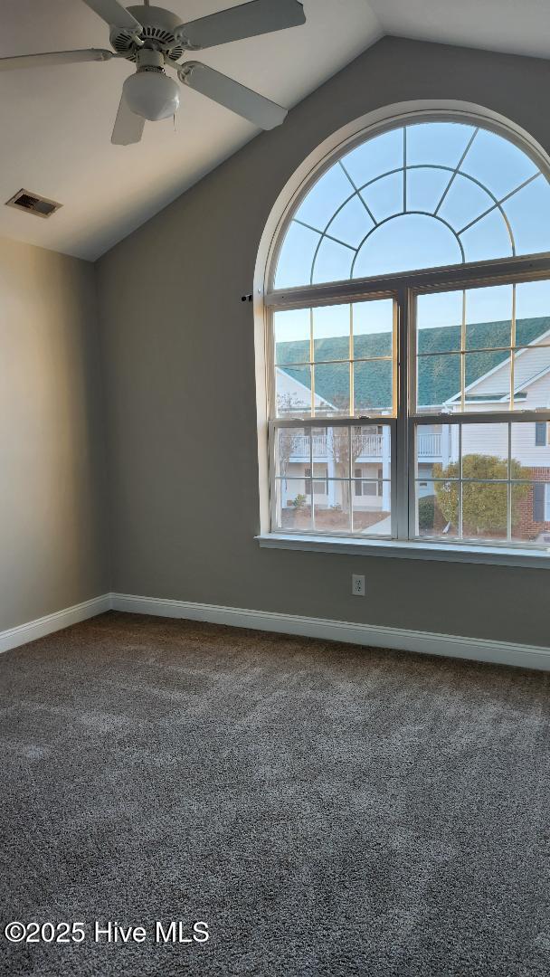 spare room featuring carpet, ceiling fan, and lofted ceiling