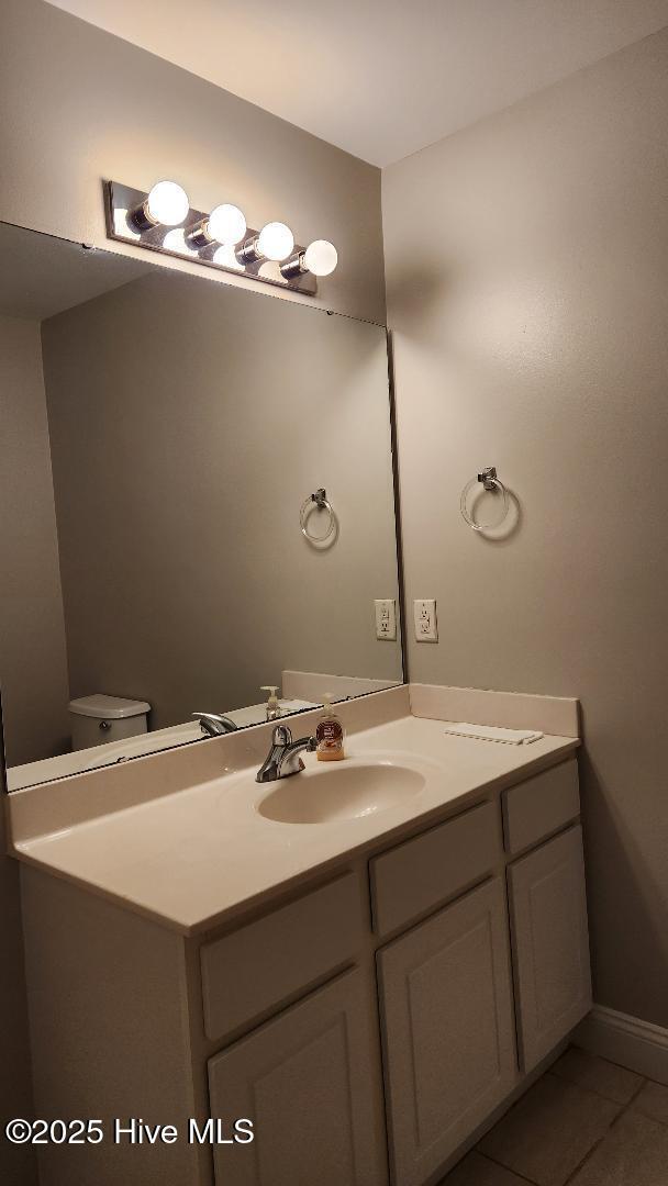 bathroom featuring tile patterned floors, vanity, and toilet