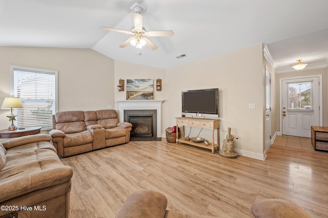 living room featuring light hardwood / wood-style floors, vaulted ceiling, and ceiling fan